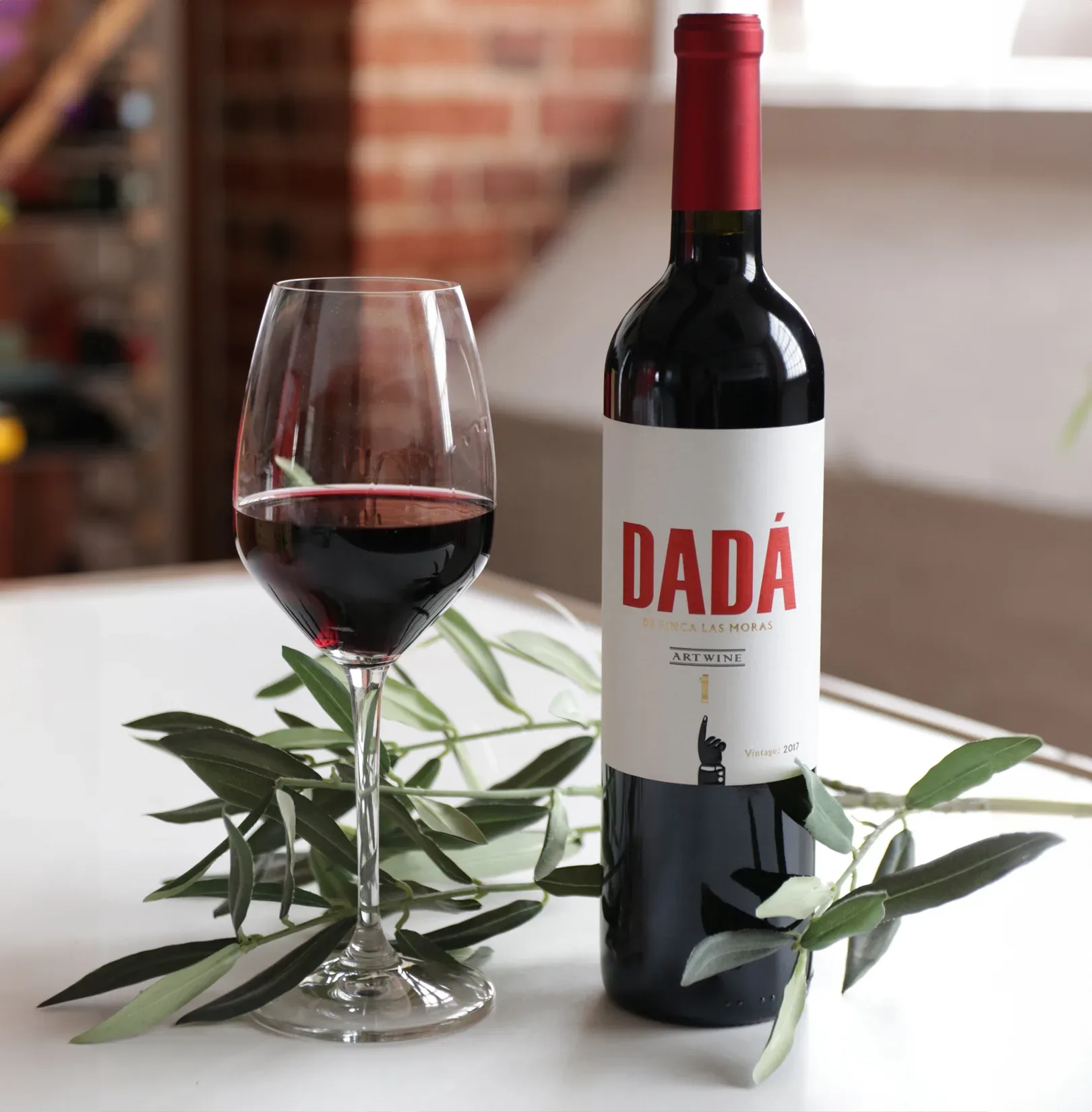 dada wine bottle and glass on a table with some leaves